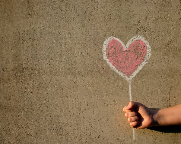 Herzluftballon auf Wand gemalt wird von einer Hand "gehalten" | © Photocase